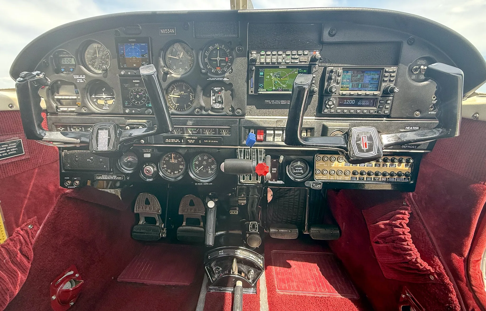 The cockpit of the N8534N aircraft, featuring a mix of analog gauges and modern Garmin digital displays.