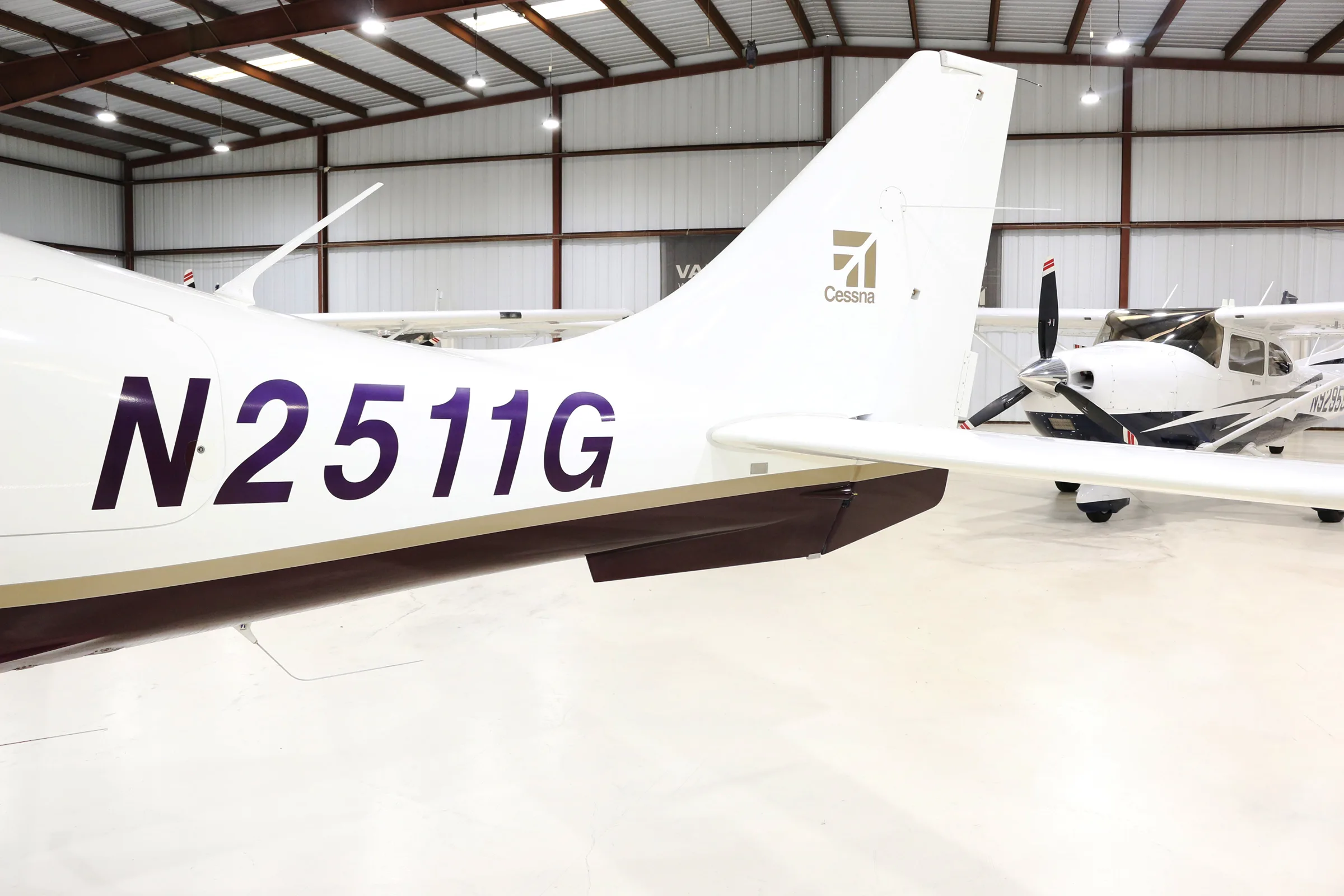 A close-up view of the tail of the white and brown aircraft N2511G, showing the registration and Cessna logo.