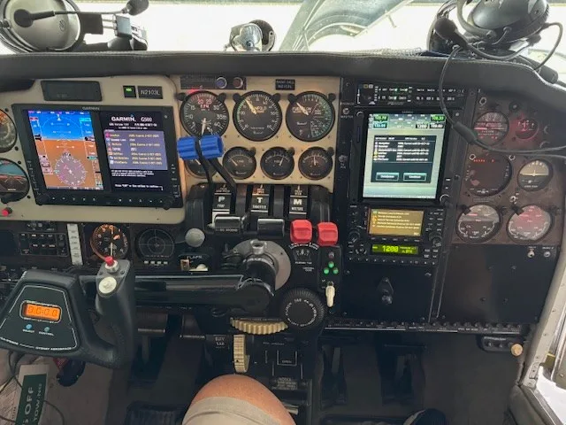 A close-up view of the aircraft's cockpit, showing the instrument panel with digital displays and traditional gauges.