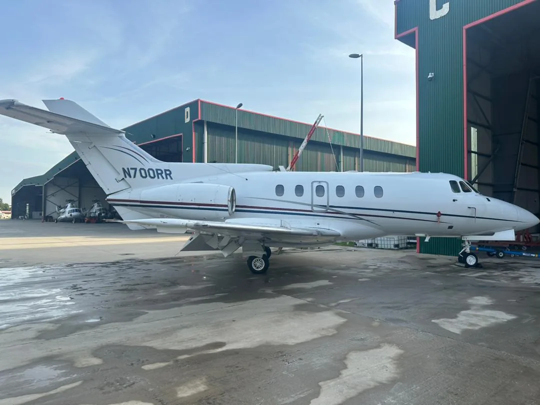 A Hawker 400XP aircraft with registration N700RR is parked outside a hangar.