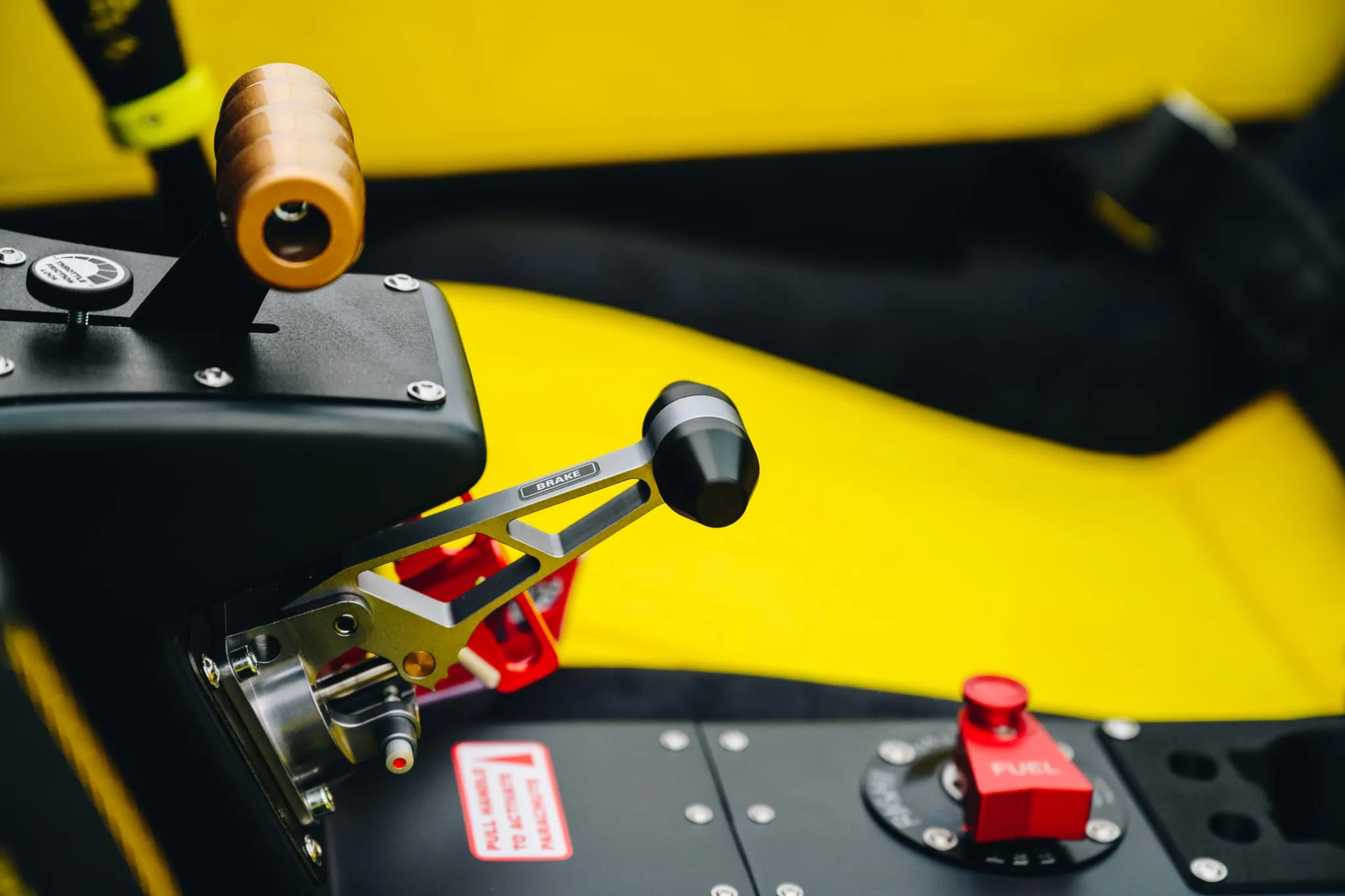 A close-up of the brake and fuel controls inside the cockpit of a yellow aircraft.