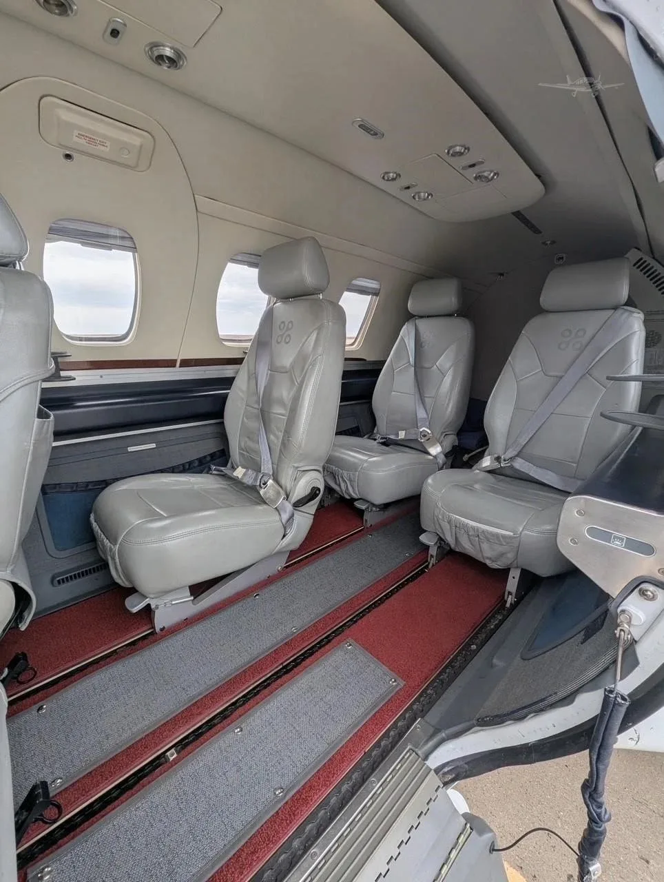 The interior cabin of an Eclipse jet, showing multiple grey leather seats and the open cabin door.