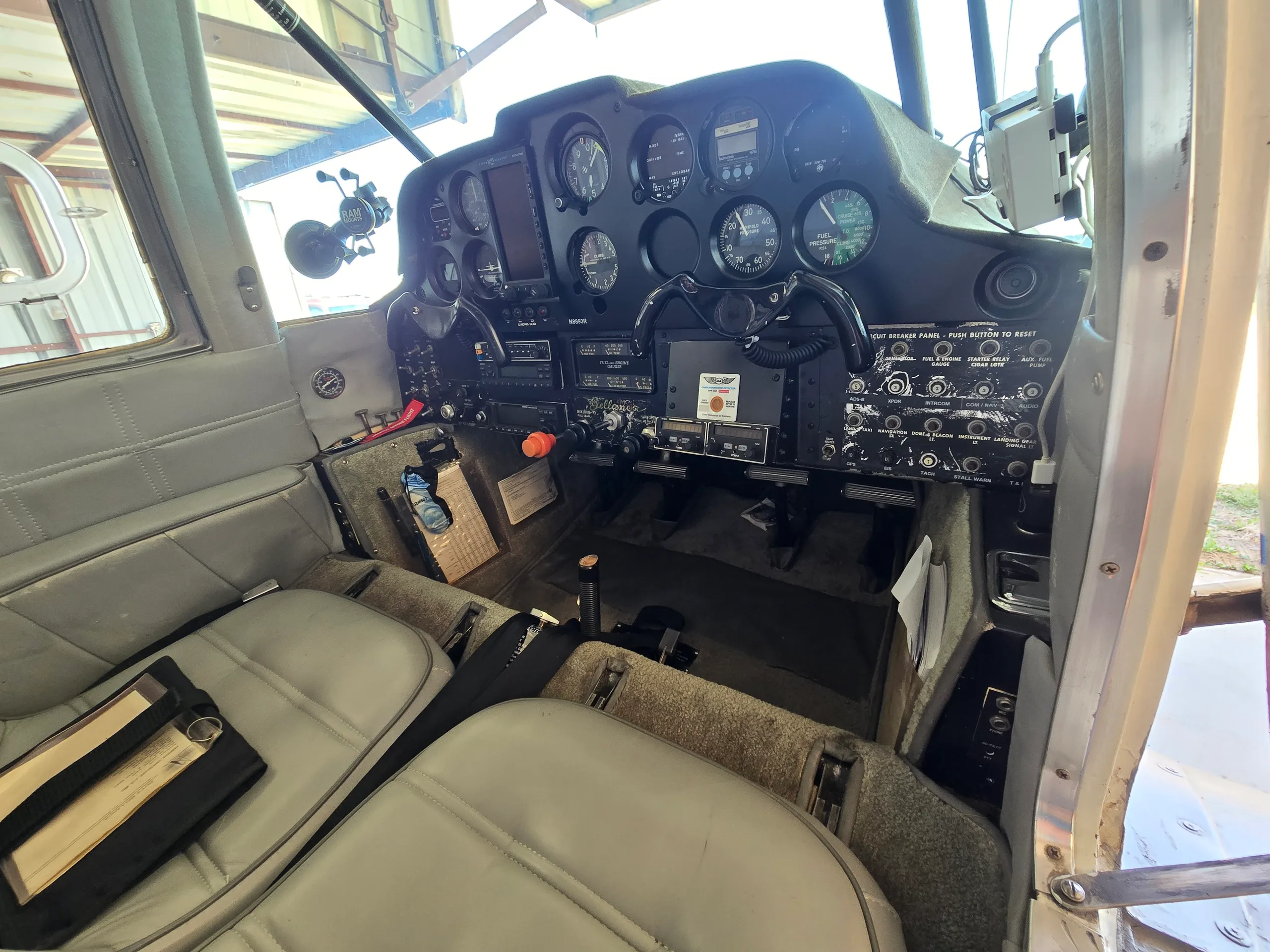 The cockpit of a light aircraft, showing the instrument panel, yoke, and pilot's seat.