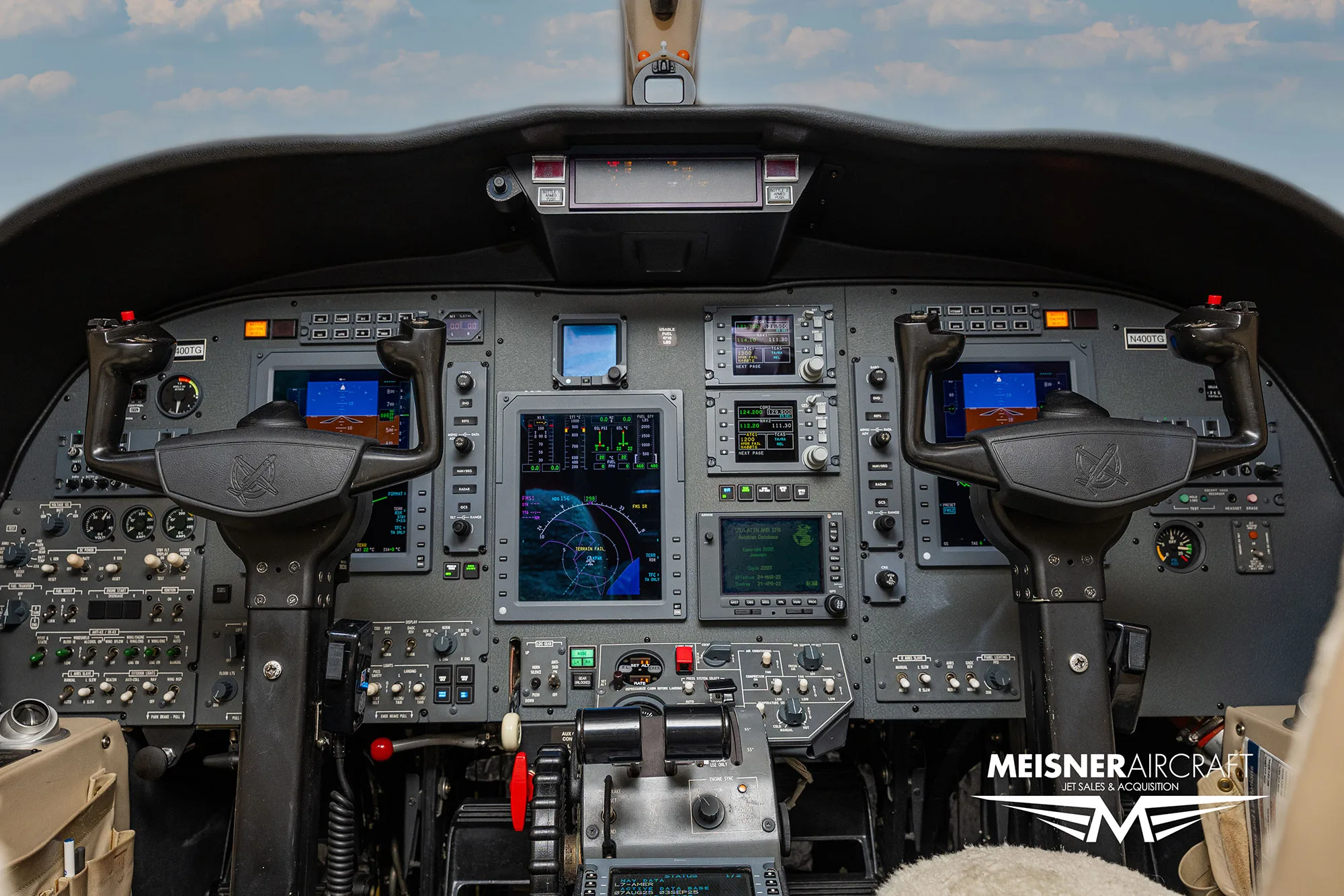 The cockpit of a business jet, showing the instrument panel with multiple digital displays and controls.