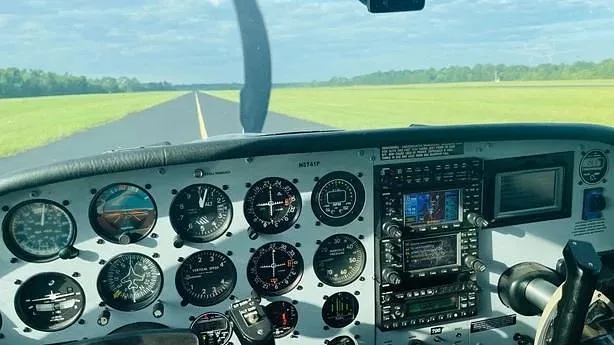 The cockpit instrument panel of N8741P with a runway visible through the windshield.