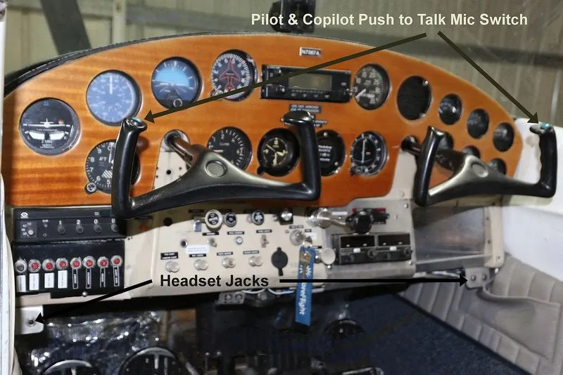 The cockpit instrument panel of a Cessna 170 aircraft with a wooden finish and various gauges and controls.
