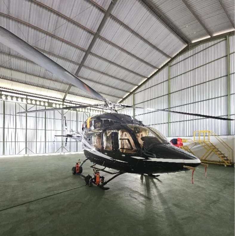 Front view of a black and white helicopter inside a hangar.