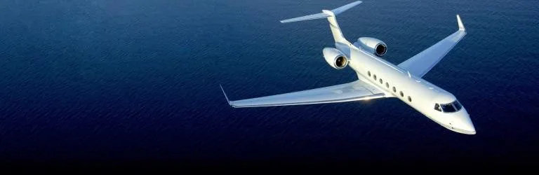 A white jet flying over the ocean.
