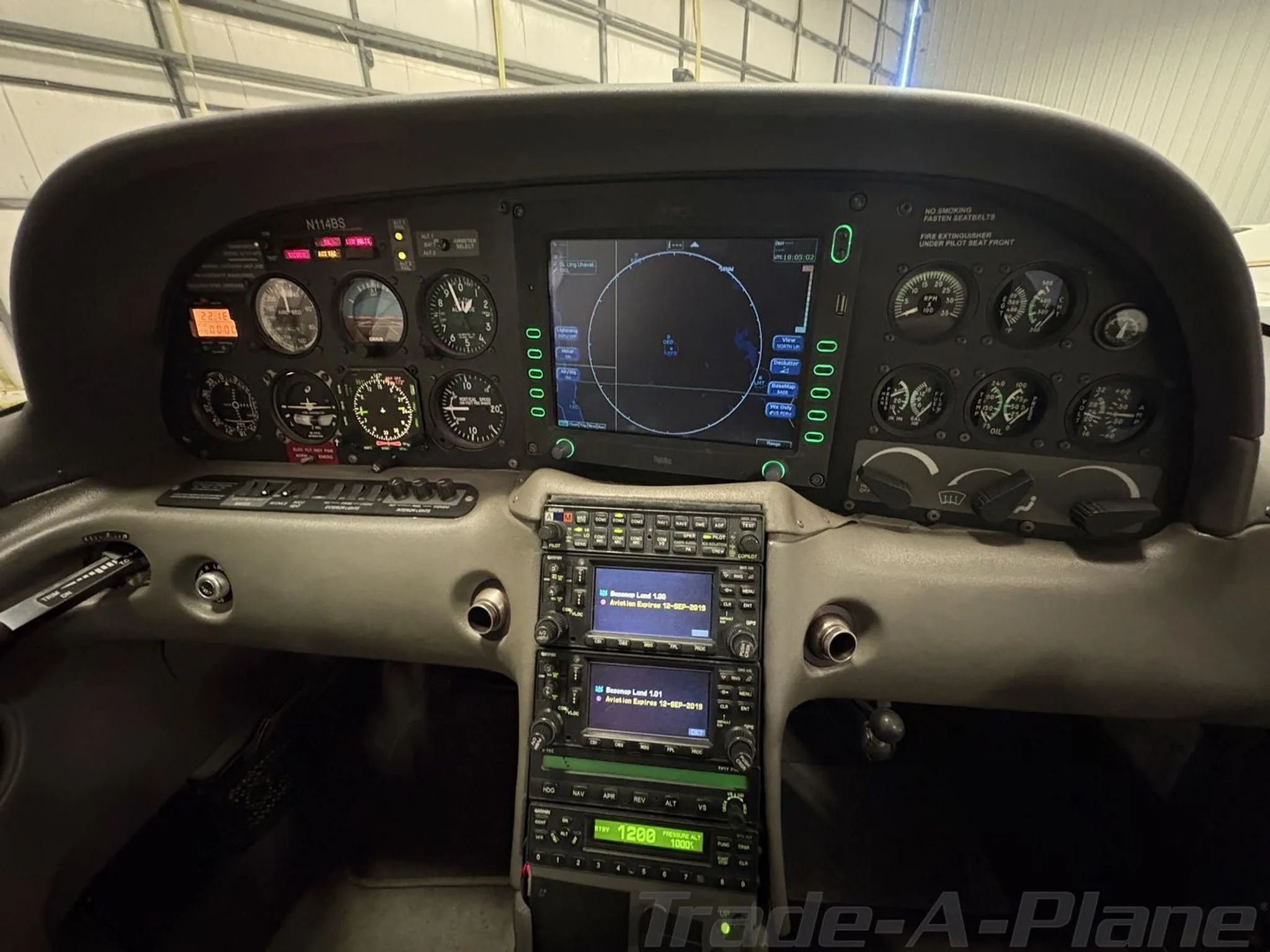 The cockpit of a Cirrus SR20, showing the instrument panel with a large display and various gauges.