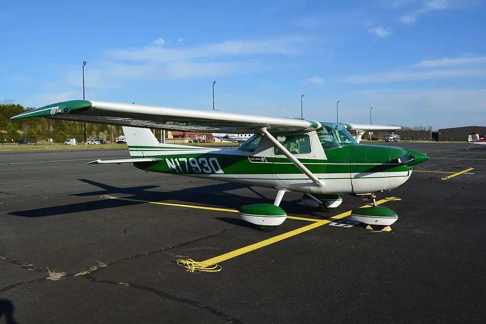 A side view of a green and white Cessna 172 aircraft, registration N1793Q, parked on an airport tarmac.