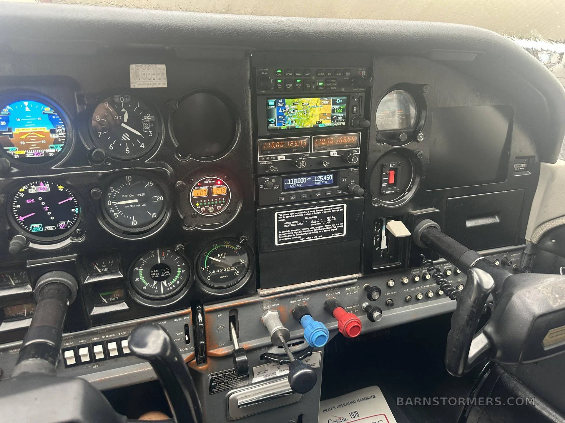 The cockpit instrument panel of a Cessna 182, featuring analog gauges and modern digital avionics, including a GPS display.