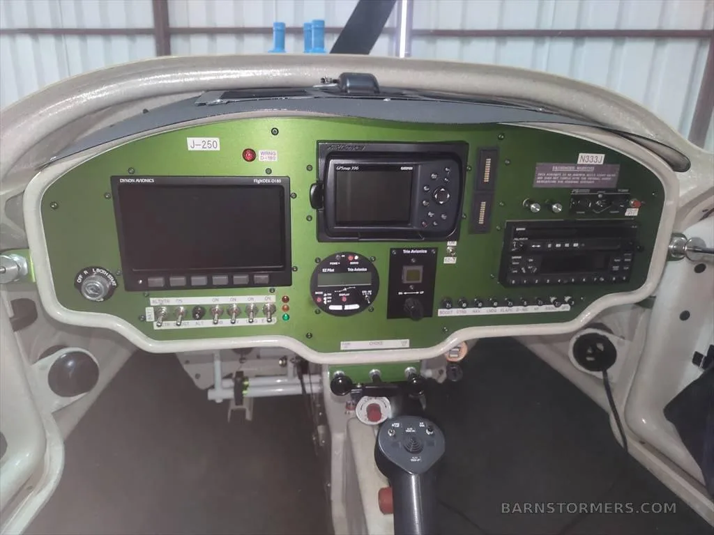 The green instrument panel of a light aircraft, showing various screens and controls.