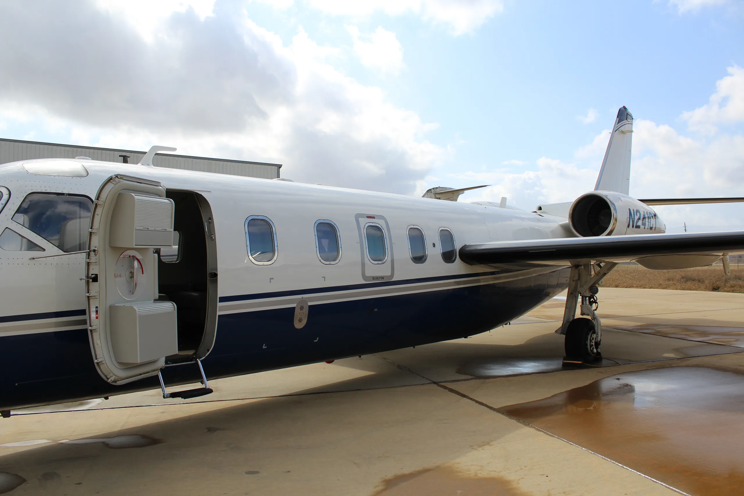 Close-up of the side of a Westwind Astra SPX aircraft with registration N241CT, showing the open door and steps.