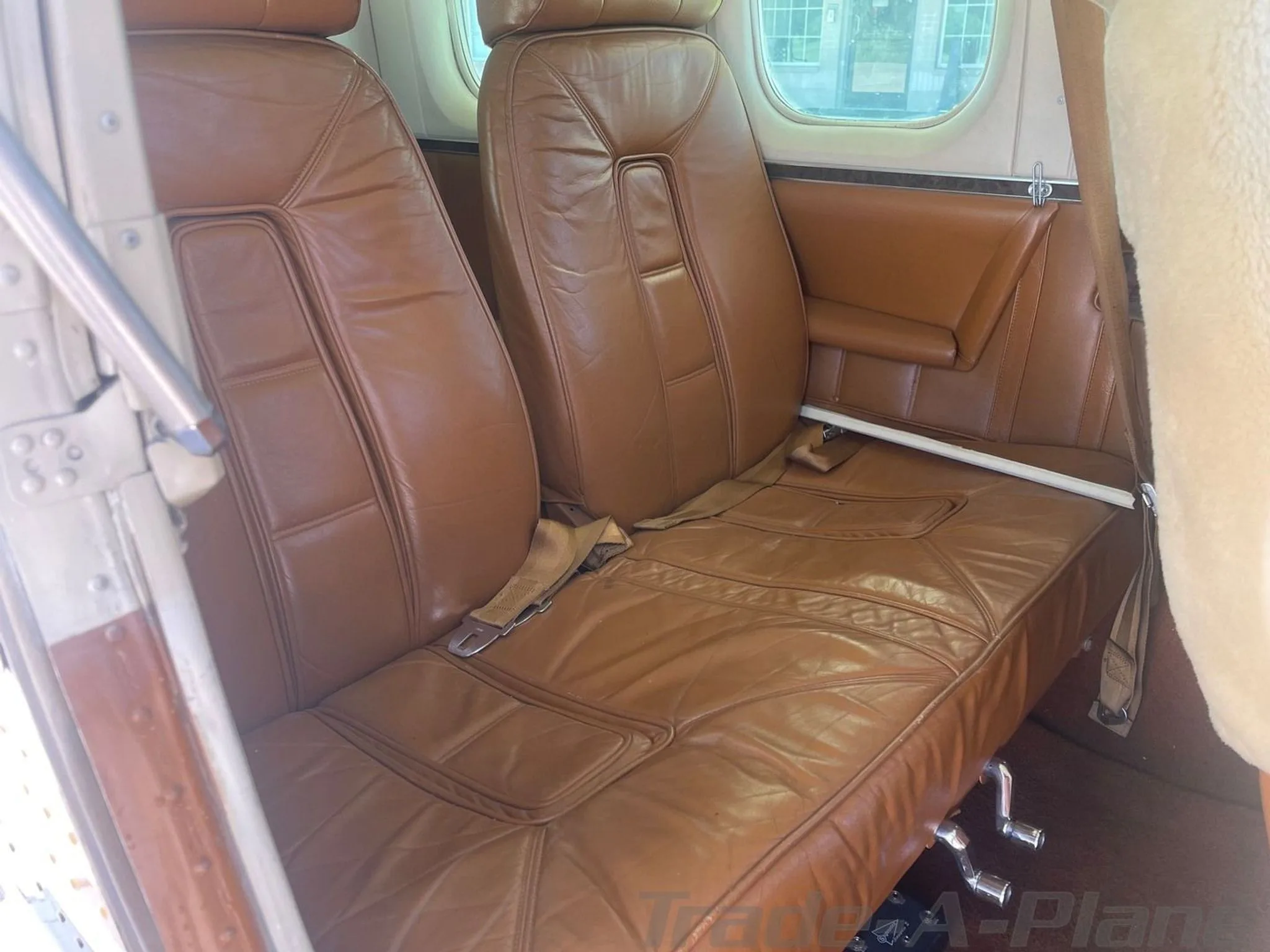 Brown leather passenger seats in the cabin of a Cessna 206 aircraft.