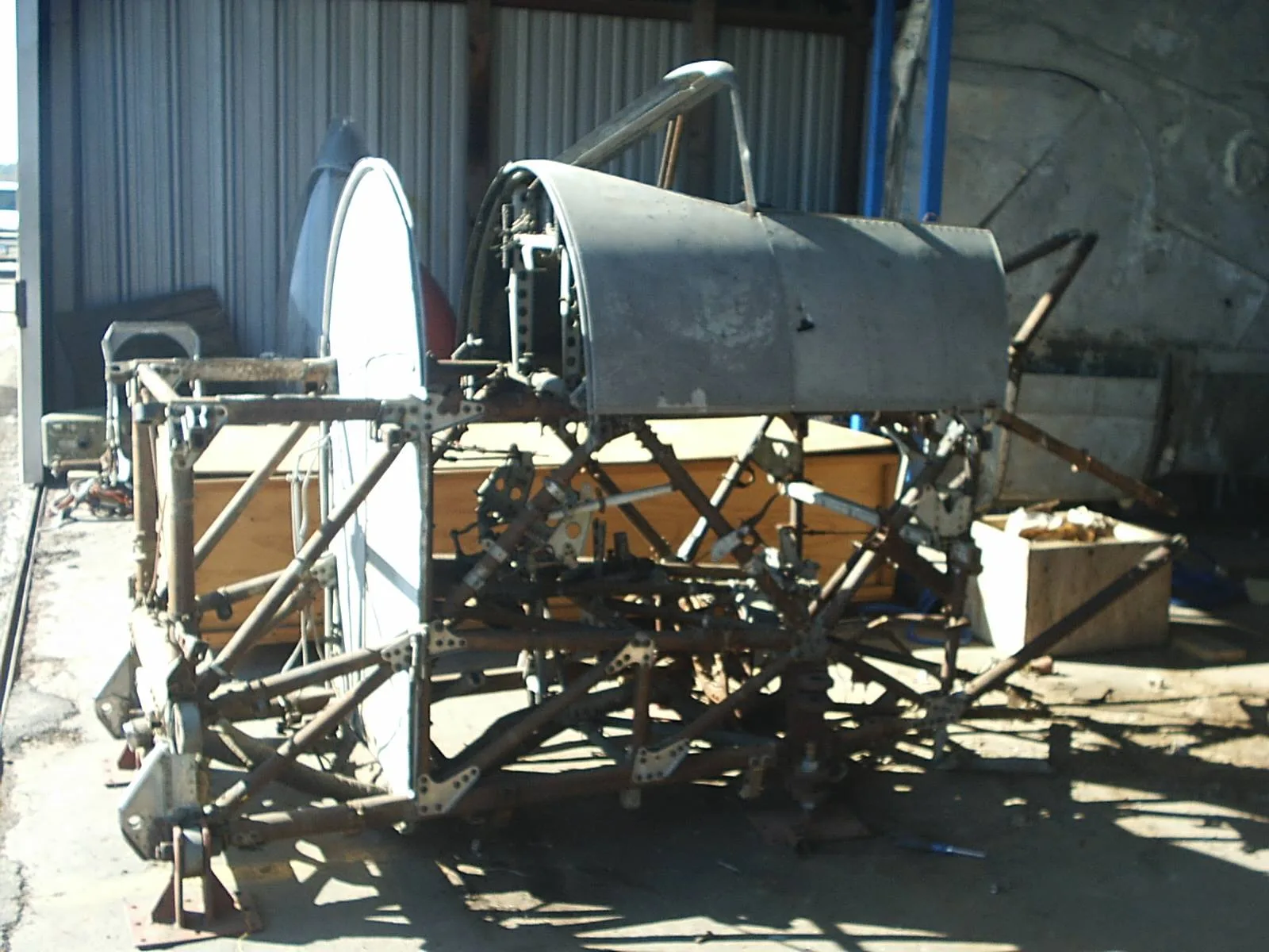 Internal structural framework of an aircraft's forward fuselage or engine mount in a workshop.