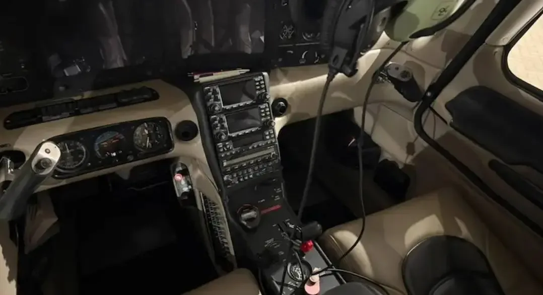 The cockpit of the aircraft, showing the instrument panel, center stack radios, and controls.