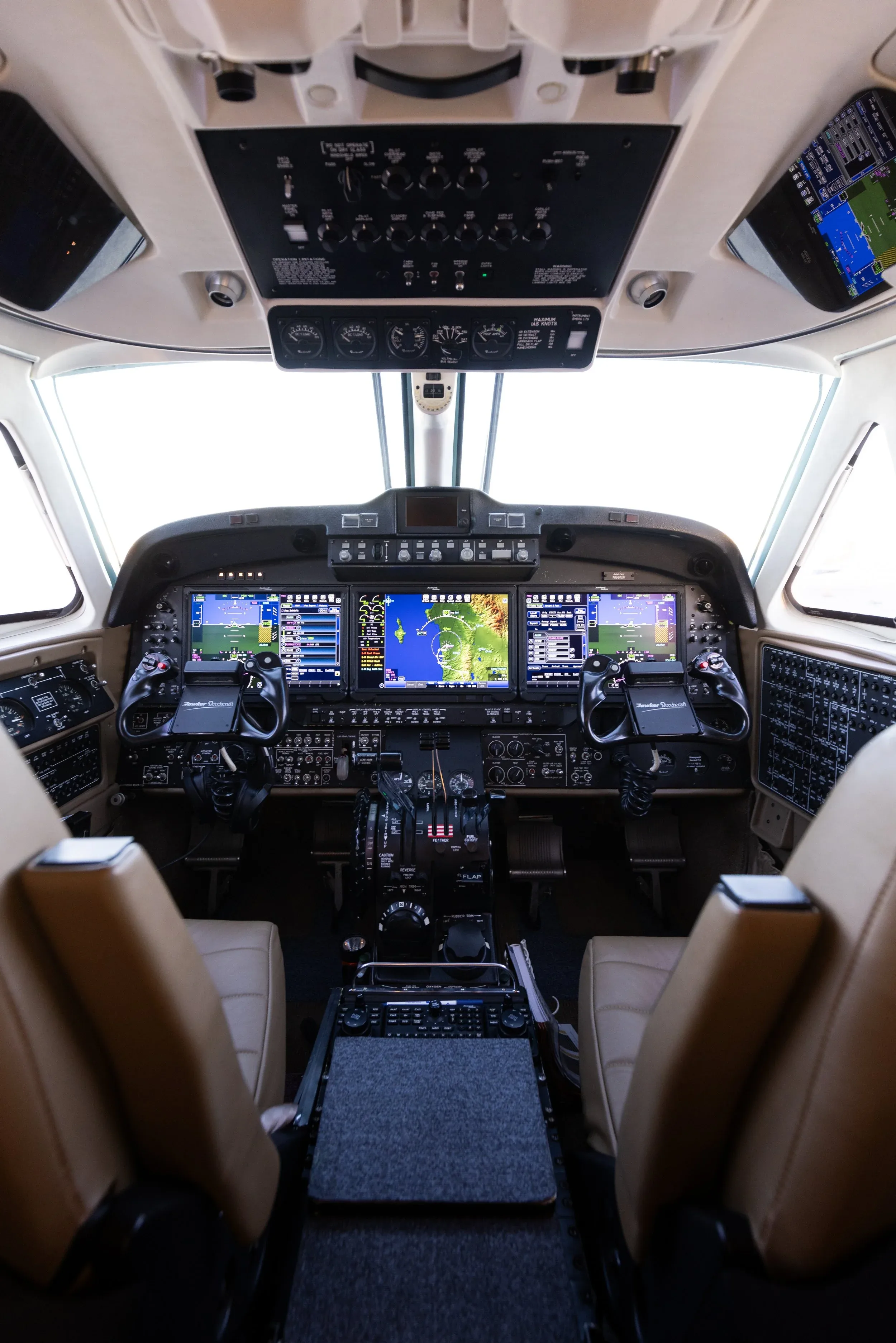 The cockpit of a King Air 350i aircraft, showing the instrument panel with multiple display screens and controls.