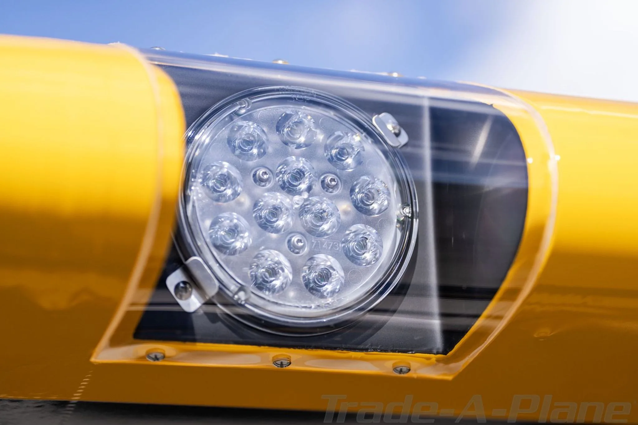 A close-up view of an LED landing light on the wing of the yellow Carbon Cub FX3.