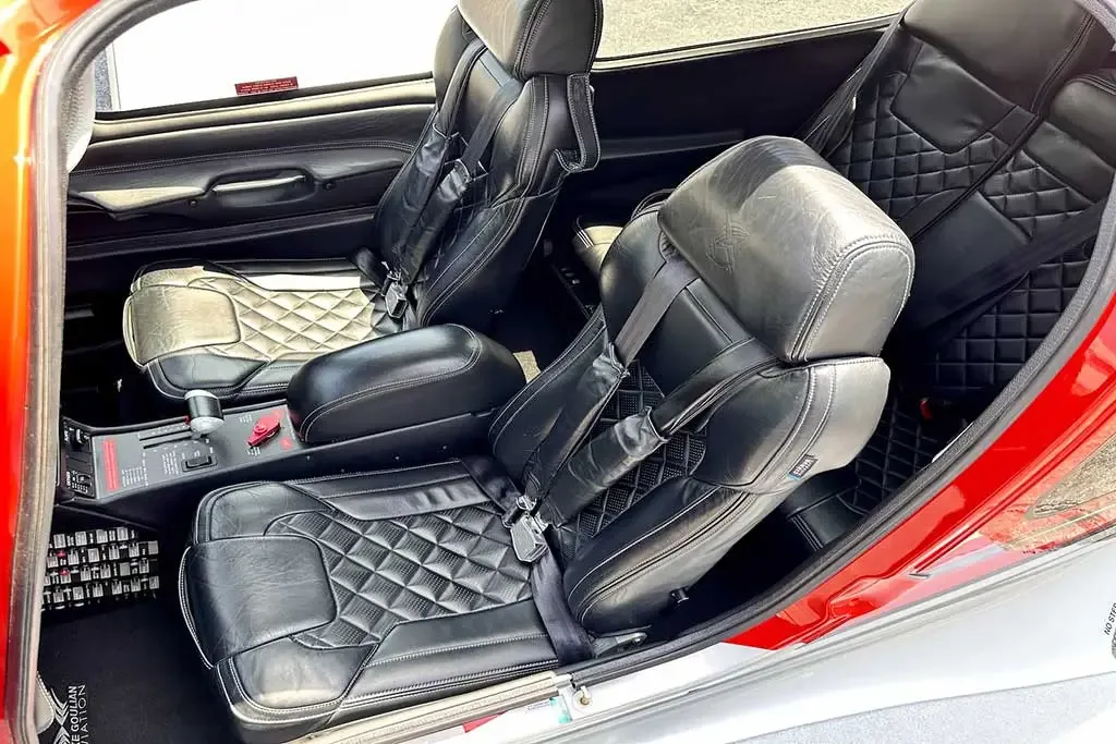 The front black leather seats and center console of a Cirrus SR22 aircraft, featuring a diamond-stitched pattern.