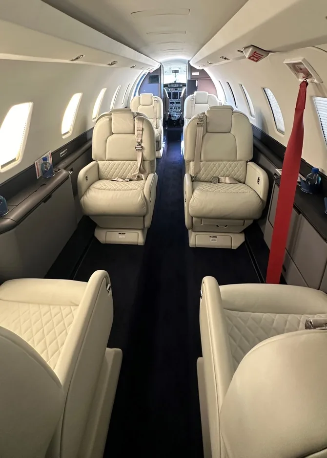 View of the aircraft's interior with white leather seats.