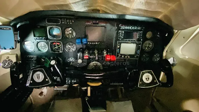 The cockpit instrument panel of a twin-engine aircraft, featuring analog gauges and modern avionics screens.