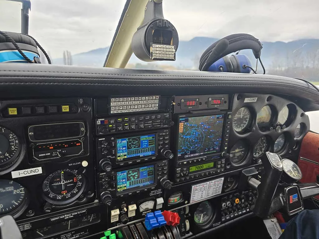 The cockpit features a detailed instrument panel with multiple analog gauges, modern digital displays, and various control switches.