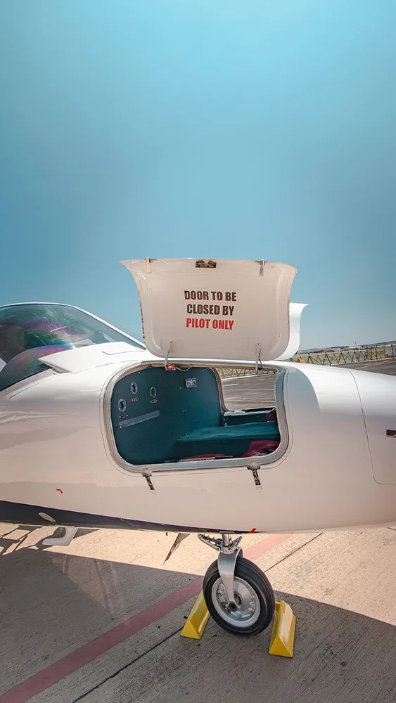 A close-up of the open baggage compartment of a white Cessna Citation jet, with a warning "DOOR TO BE CLOSED BY PILOT ONLY".