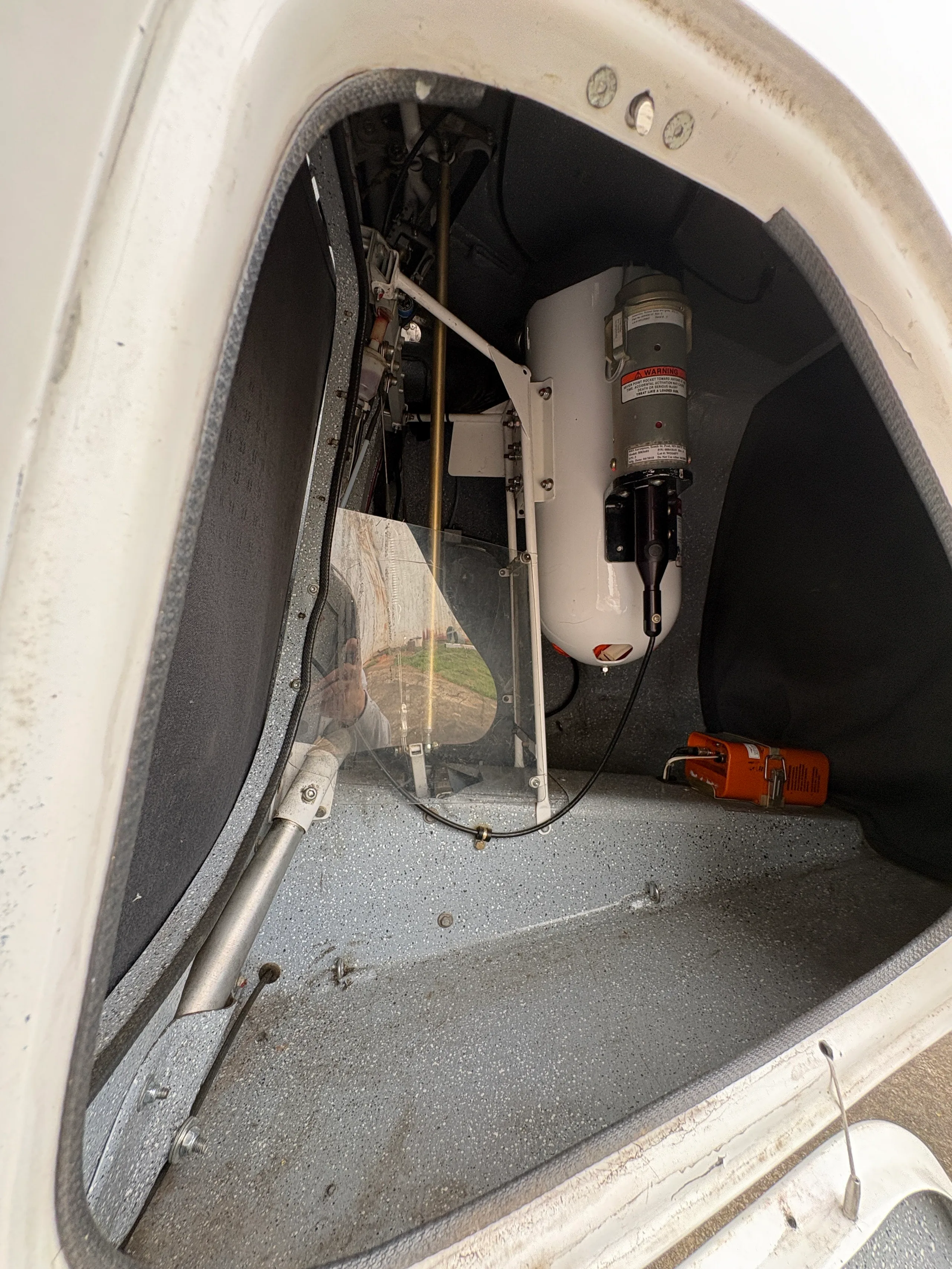 An open compartment inside the aircraft reveals a white ballistic parachute canister and other internal mechanisms.