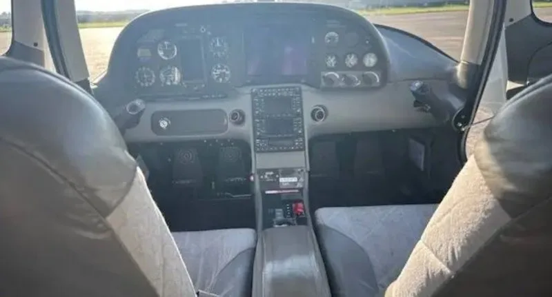 The cockpit and front cabin of a Cirrus SR20, showing the instrument panel and front seats.