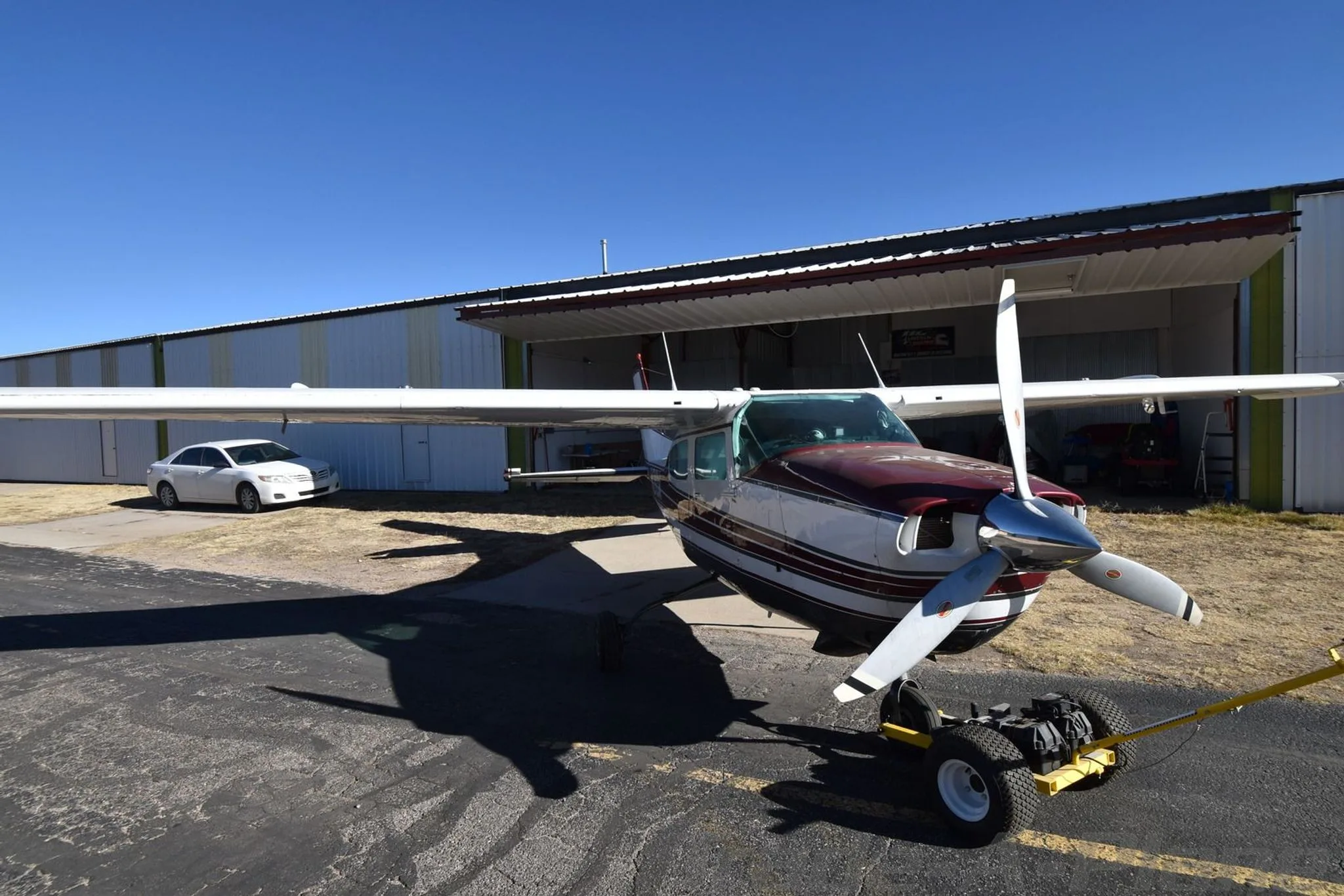 Front view of the Cessna 210K with a hangar in the background.