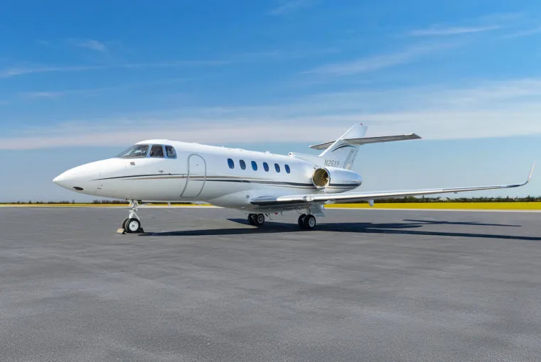 A white Cessna Citation business jet, registration N26XP, parked on a tarmac under a clear blue sky.