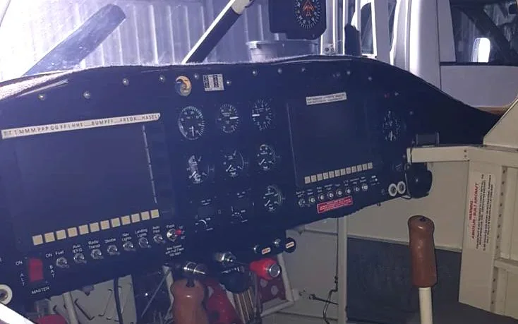 A wider view of an aircraft cockpit instrument panel, showing multiple gauges, digital screens, and control switches.