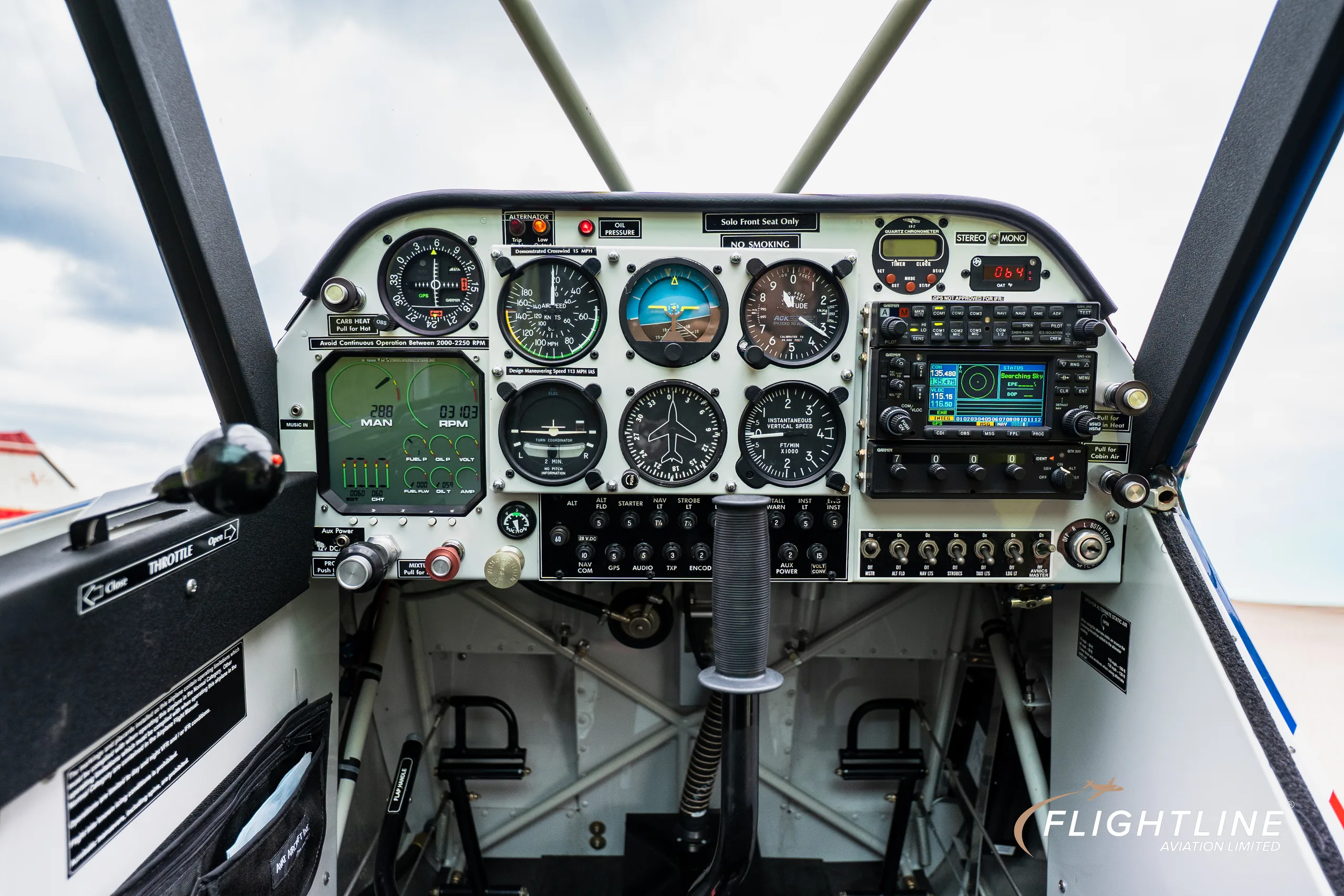 The detailed instrument panel of an Aviat Aircraft Husky A-1B, featuring analog gauges and a digital display.