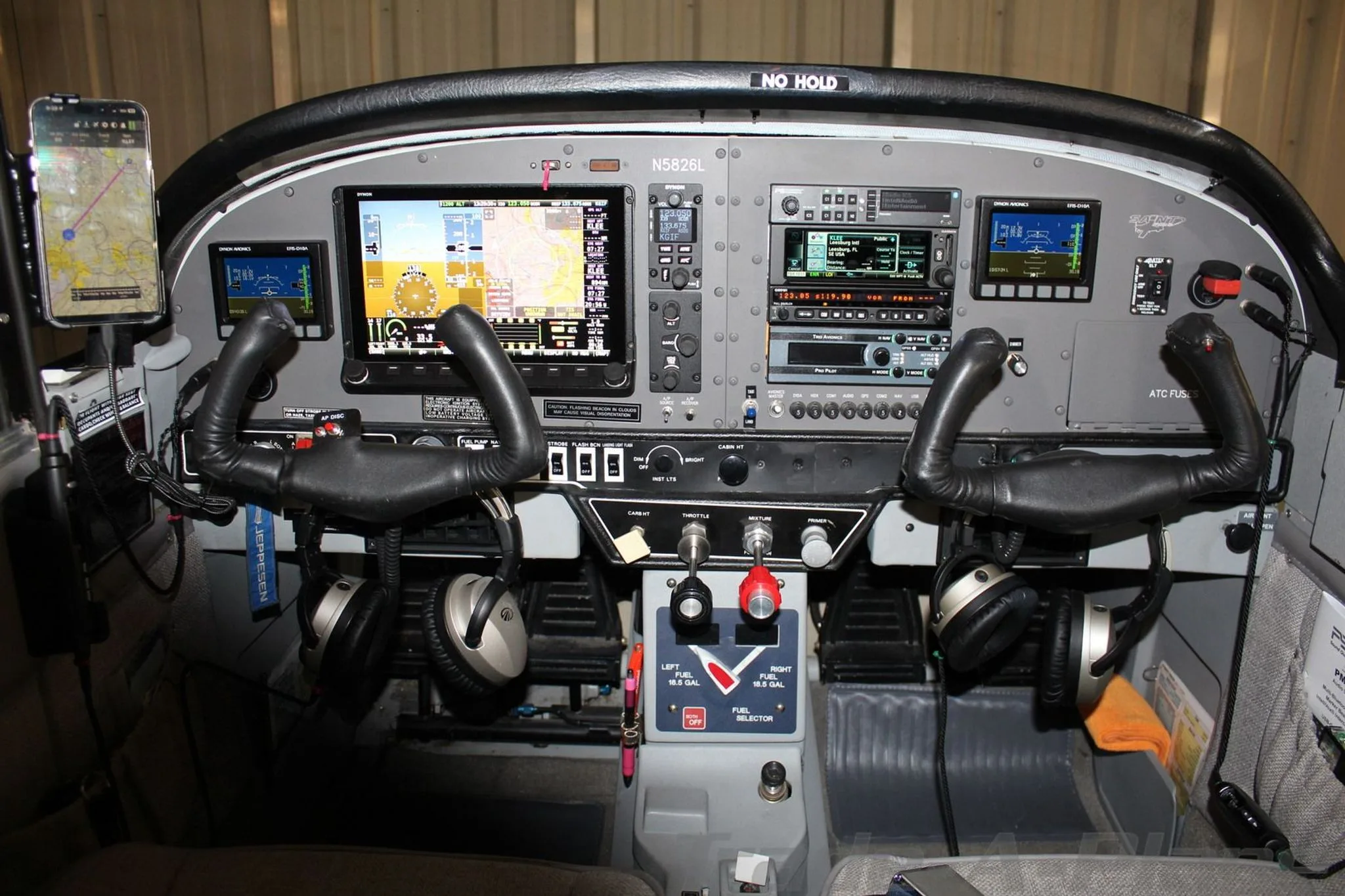 The cockpit of the N5826L aircraft, featuring a modern avionics panel with multiple screens and dual yokes.