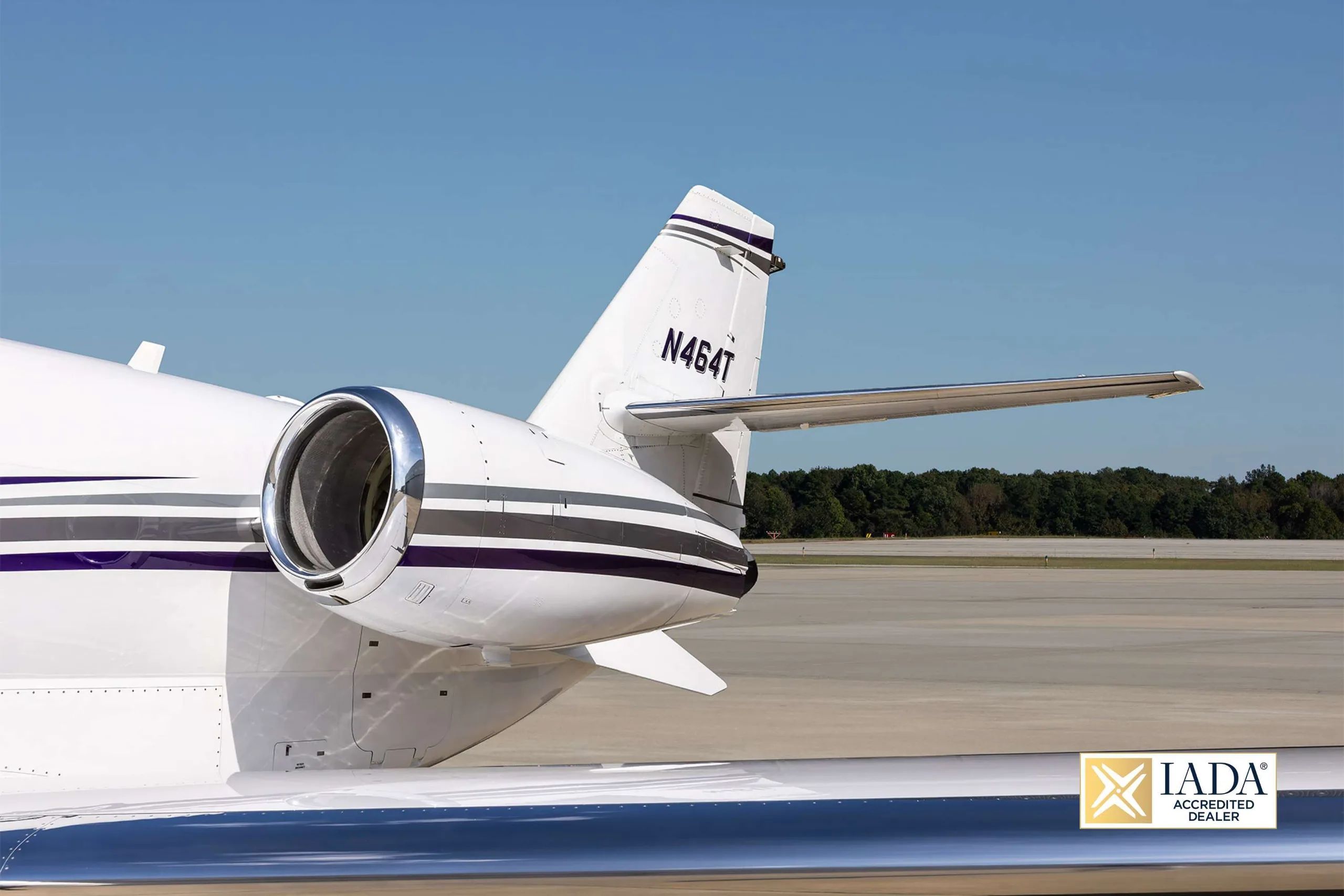 A close-up of the tail section of the N464T business jet, showing the engine exhaust and registration.