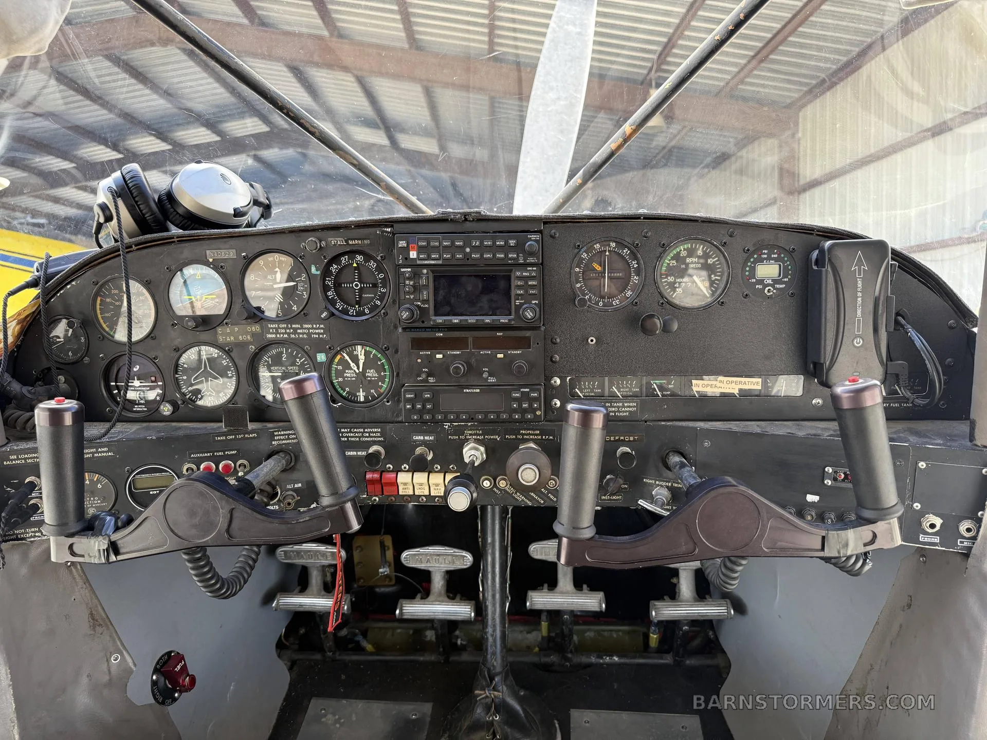 The cockpit of a small aircraft featuring a detailed instrument panel and dual yokes.
