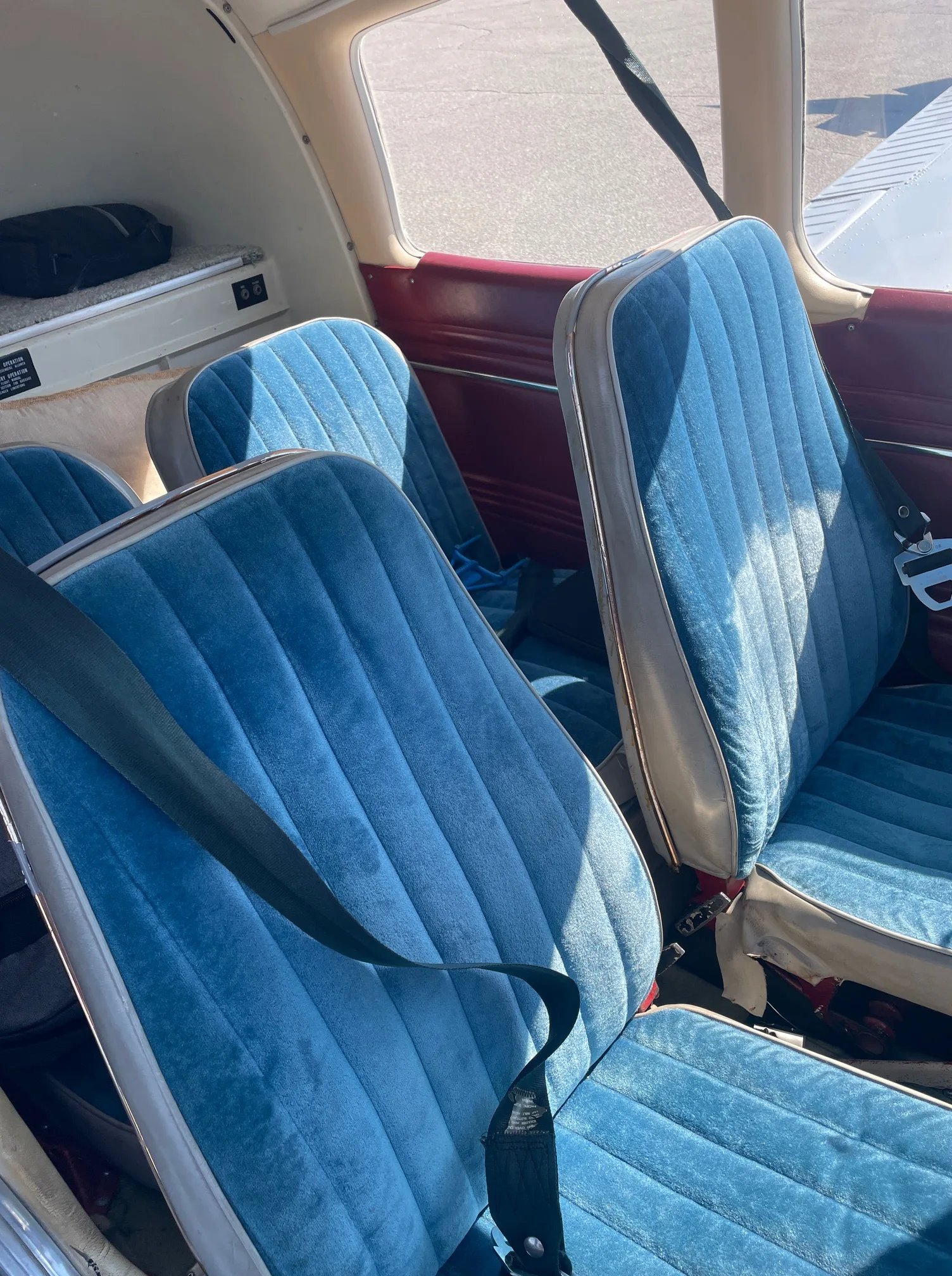 The blue upholstered passenger seats inside a small aircraft cabin.