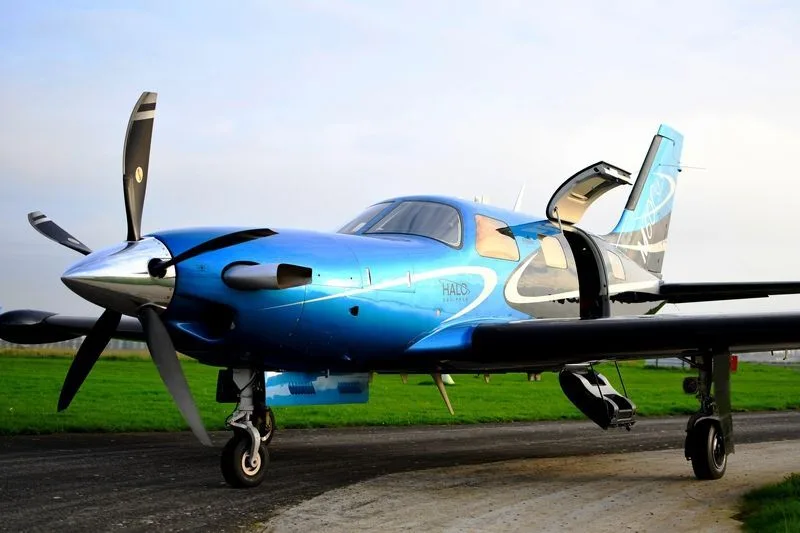 A blue Piper PA46 M600 parked on the ground.