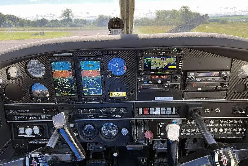 The cockpit instrument panel of a Piper PA-28 aircraft, featuring modern digital displays and traditional gauges.
