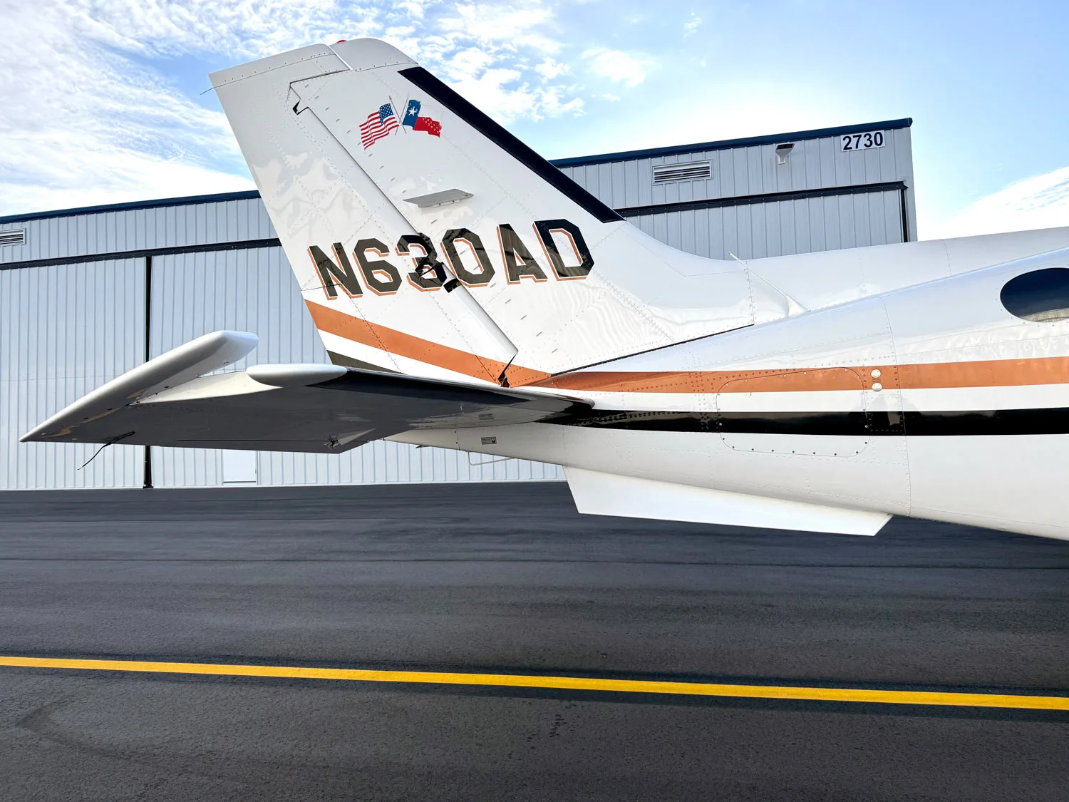 A close-up of the tail of the N630AD aircraft, showing the registration number and US and Texas flags.