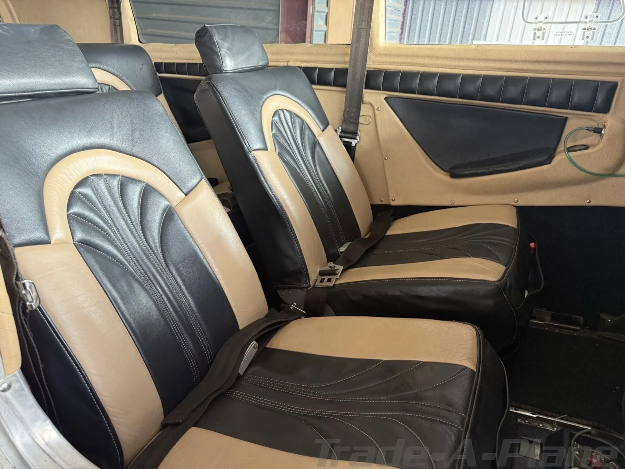 Interior view of the aircraft cabin with black and tan leather seats.