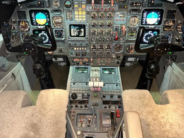 The aircraft's cockpit, featuring a detailed instrument panel with multiple screens and two control yokes.