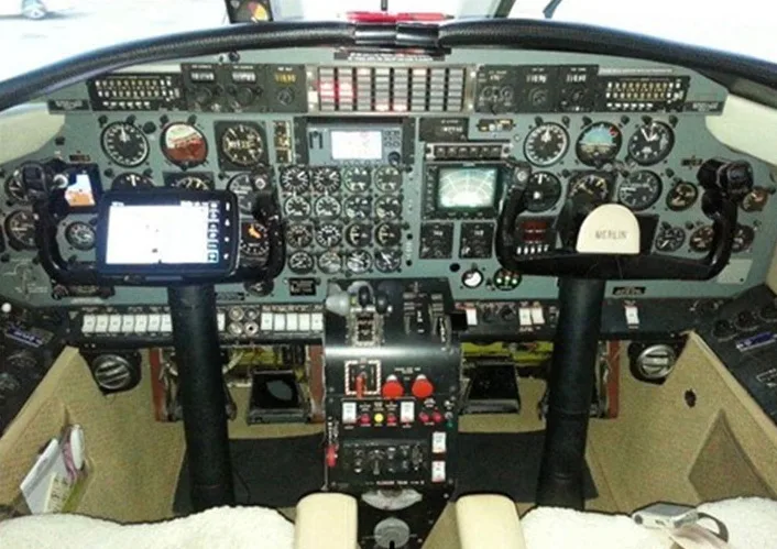 The aircraft's cockpit features a complex instrument panel with analog gauges, digital displays, and two control yokes.