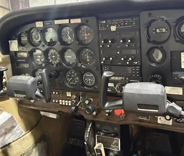 The instrument panel of a single-engine aircraft, showing various gauges, radios, and controls.