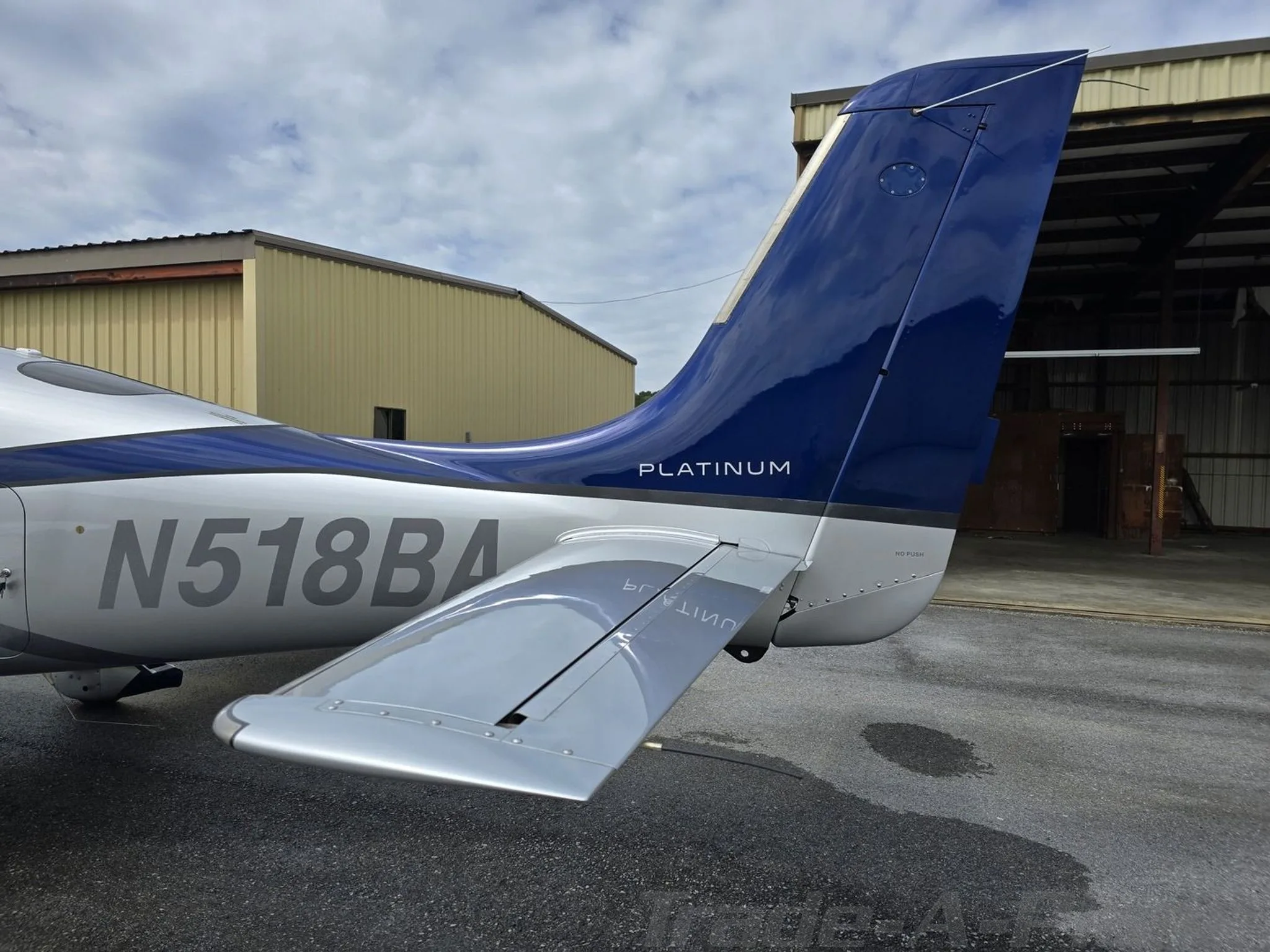 Close-up of the tail of a Cirrus SR22T aircraft, showing the blue vertical stabilizer and N518BA registration.