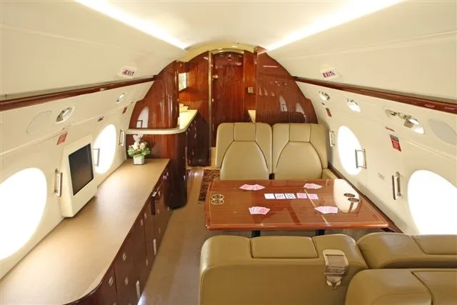 The aircraft's interior features a table with playing cards and a refreshment area.