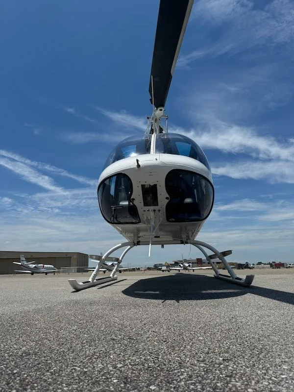 Front view of a white Bell 206L-4 helicopter on the tarmac.