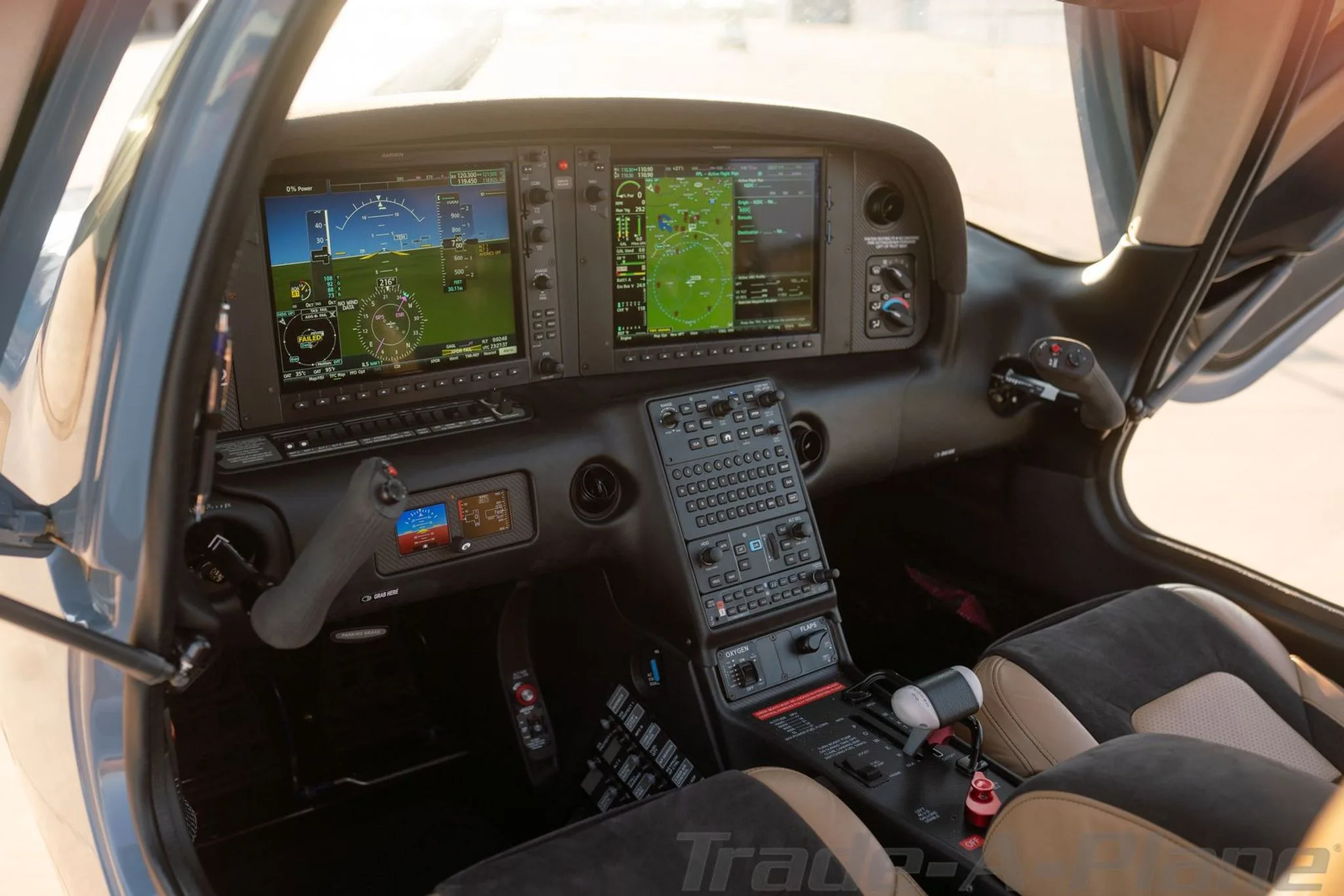 The cockpit of a Cirrus SR22 aircraft, featuring a glass panel with multiple screens and tan and black seats.