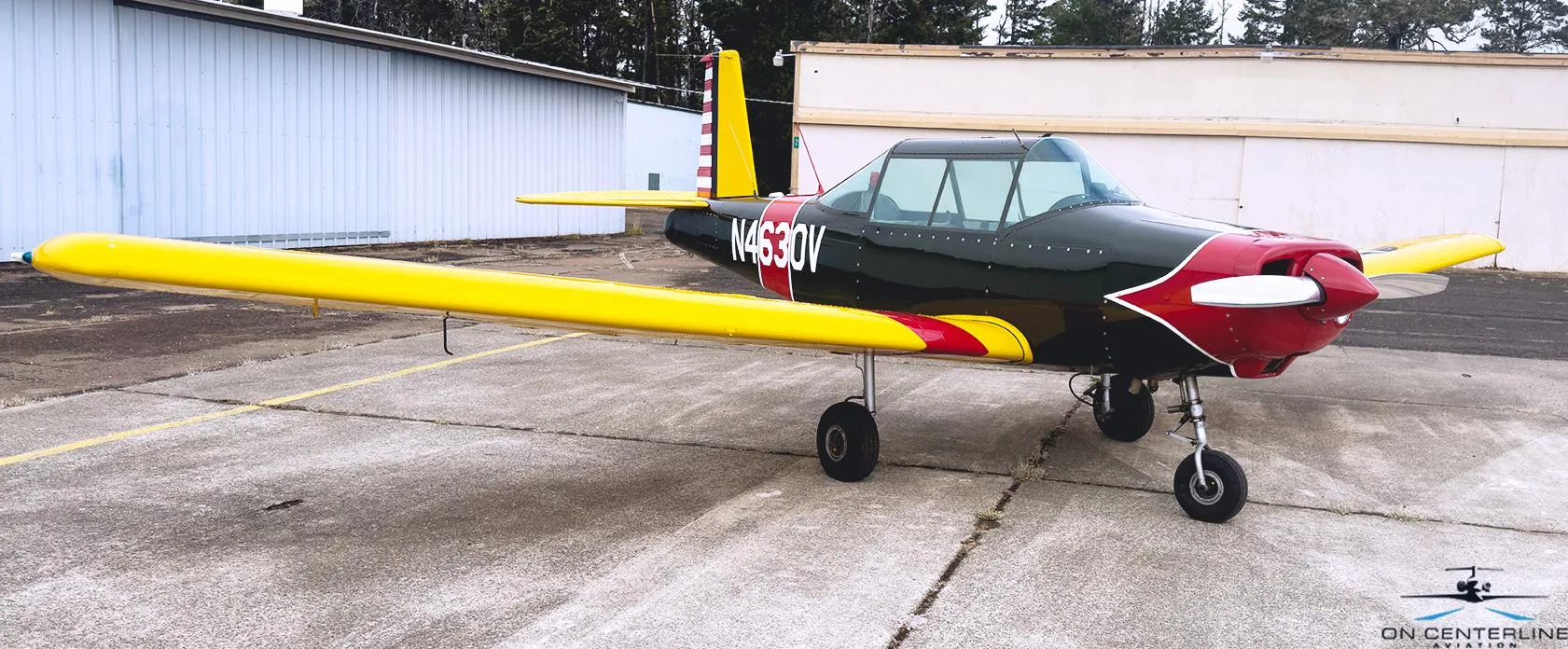 A black and red aircraft with yellow wings and tail, registration N4630V, parked on a concrete tarmac.
