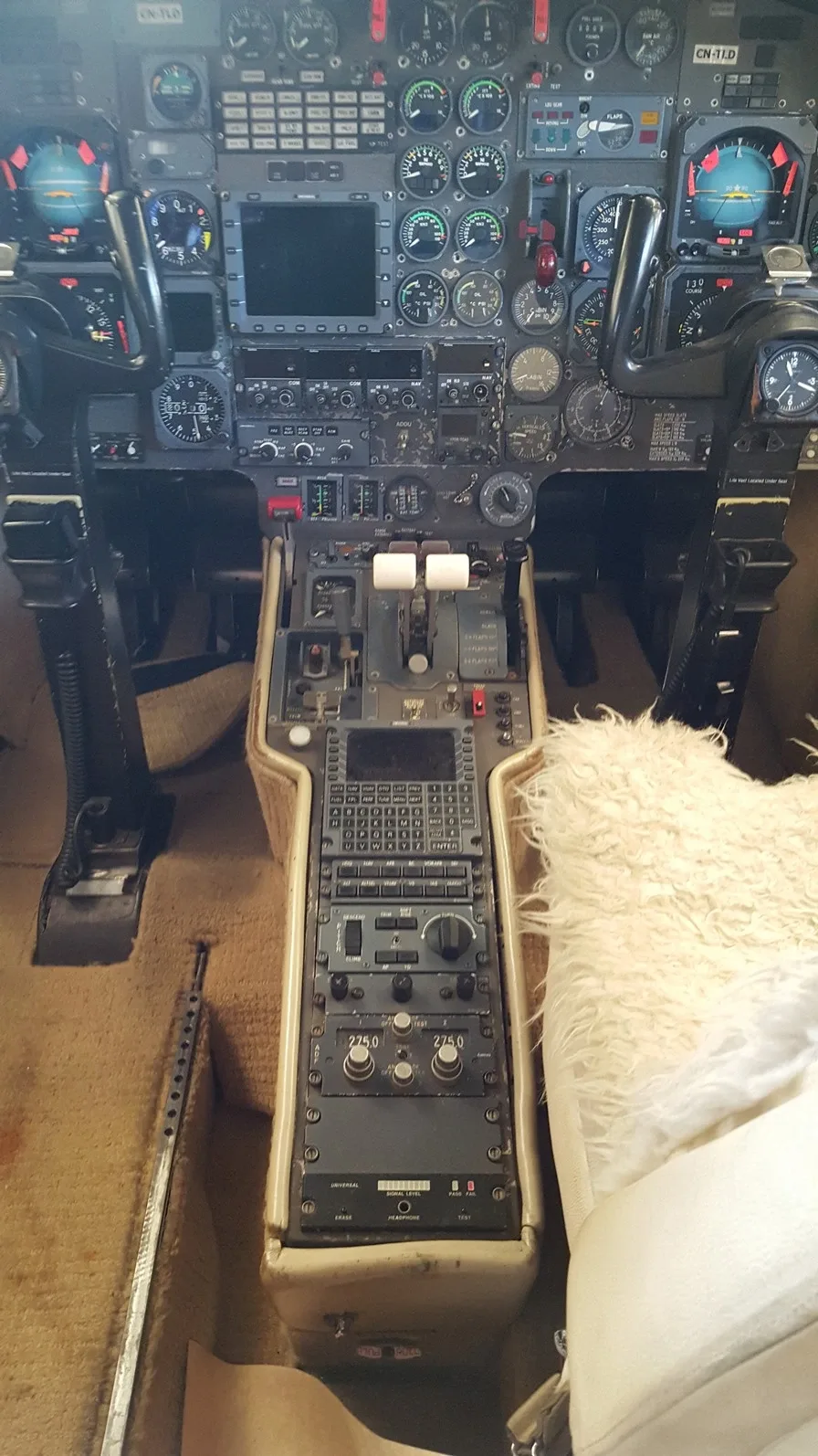 An overhead view of a business jet cockpit, showing the detailed instrument panel and the central control pedestal.